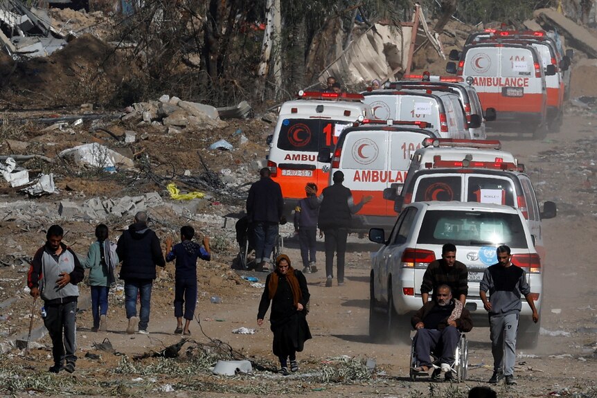 几辆救护车行驶在加沙地带崎岖的路面上。