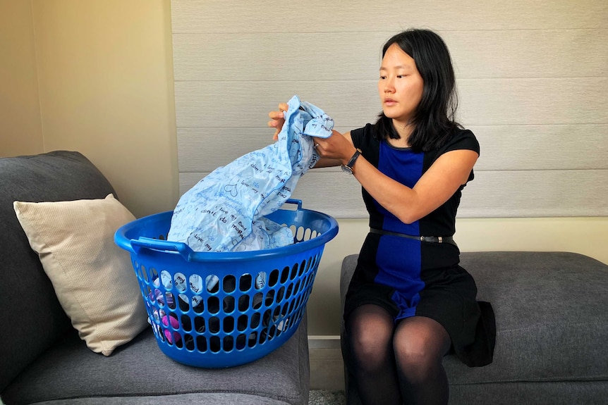 Mary Creelman takes the washing from a basket and folds it.