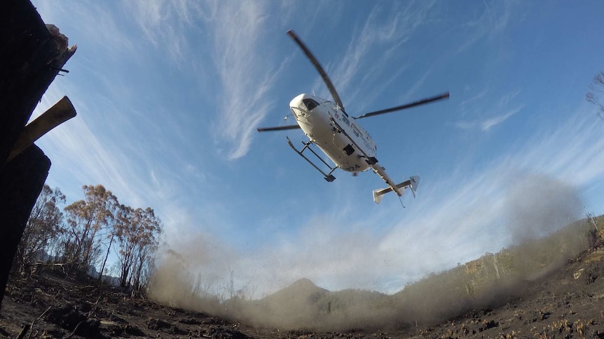 A helicopter lands at Gell River fire in Tasmania's remote south-west