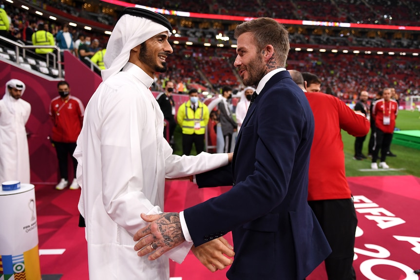 David Beckham and H.E Sheikh Jassim Bin Hamad Al Thani embrace at a football match