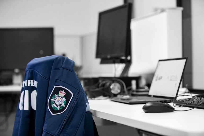 An AFP jacket sits over a chair with computers in the background