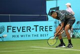 Nick Kyrgios leaning over the line and gesturing at it while yelling.