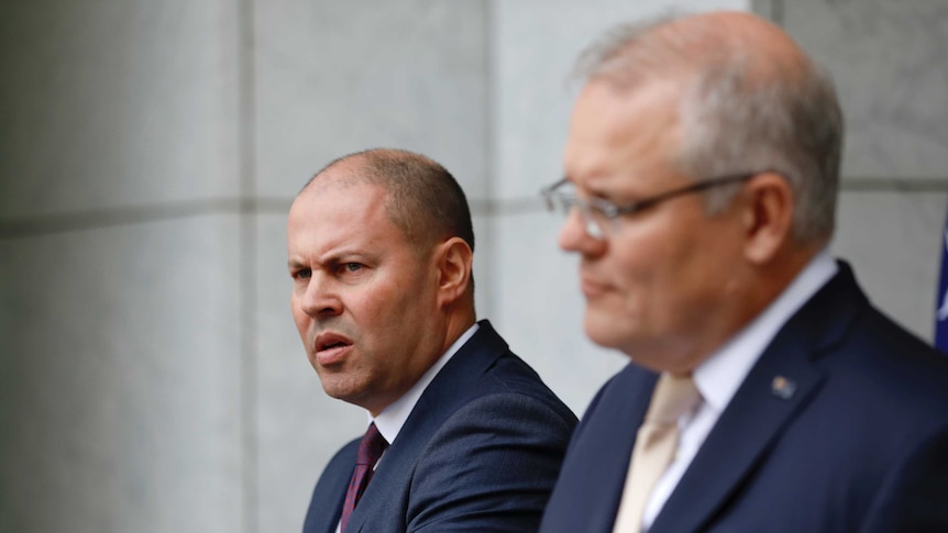 Josh Frydenberg and Scott Morrison stand behind podia in a marble-walled courtyard