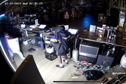 Two people behind a shop counter during a business break-in.