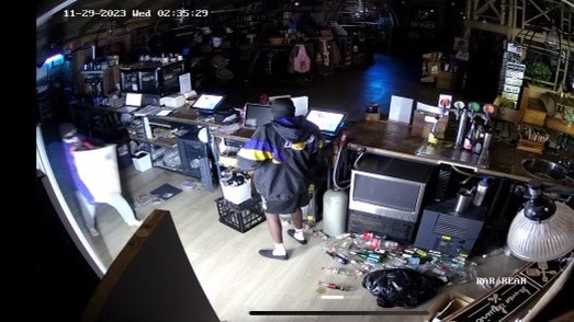 Two people behind a shop counter during a business break-in.
