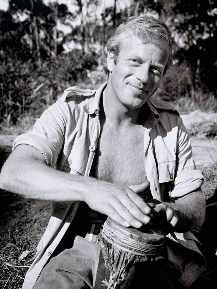 A black and white image of a man playing a small drum