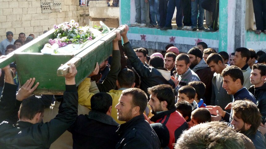 Anti-government protesters carry the coffin of Abdul Haleem Baqour during his funeral in Hula near Homs