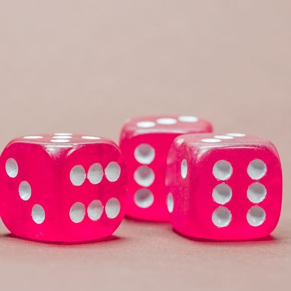 Photograph of 4 dice that are pink. The background is white