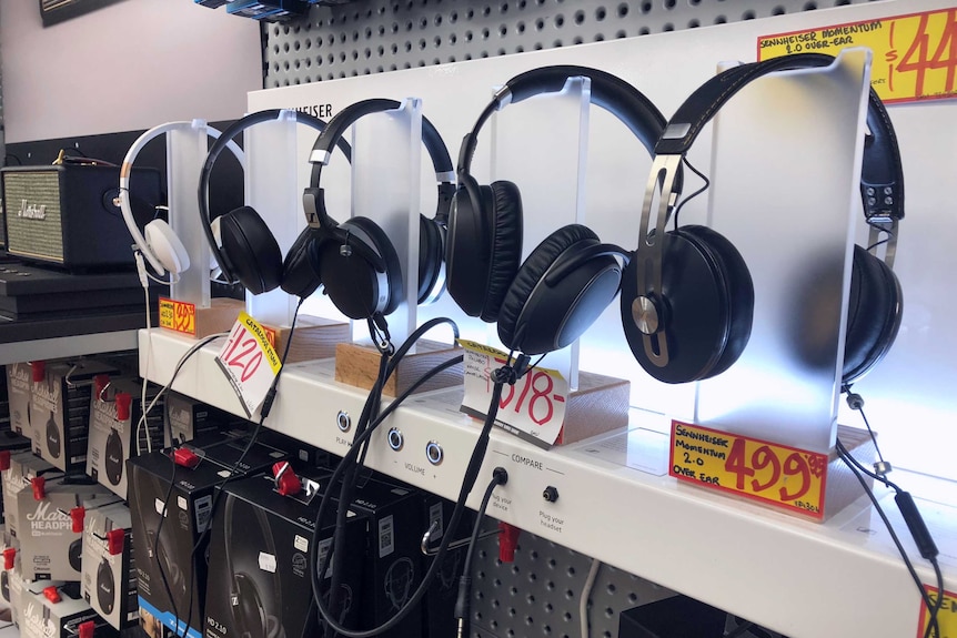 A row of headphones for sale in a shop