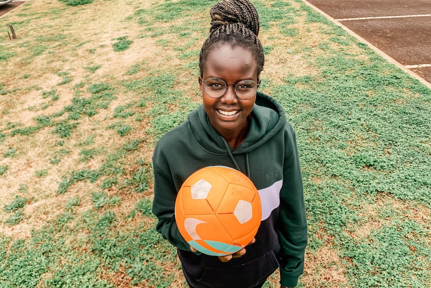 a young woman holds a soccer ball