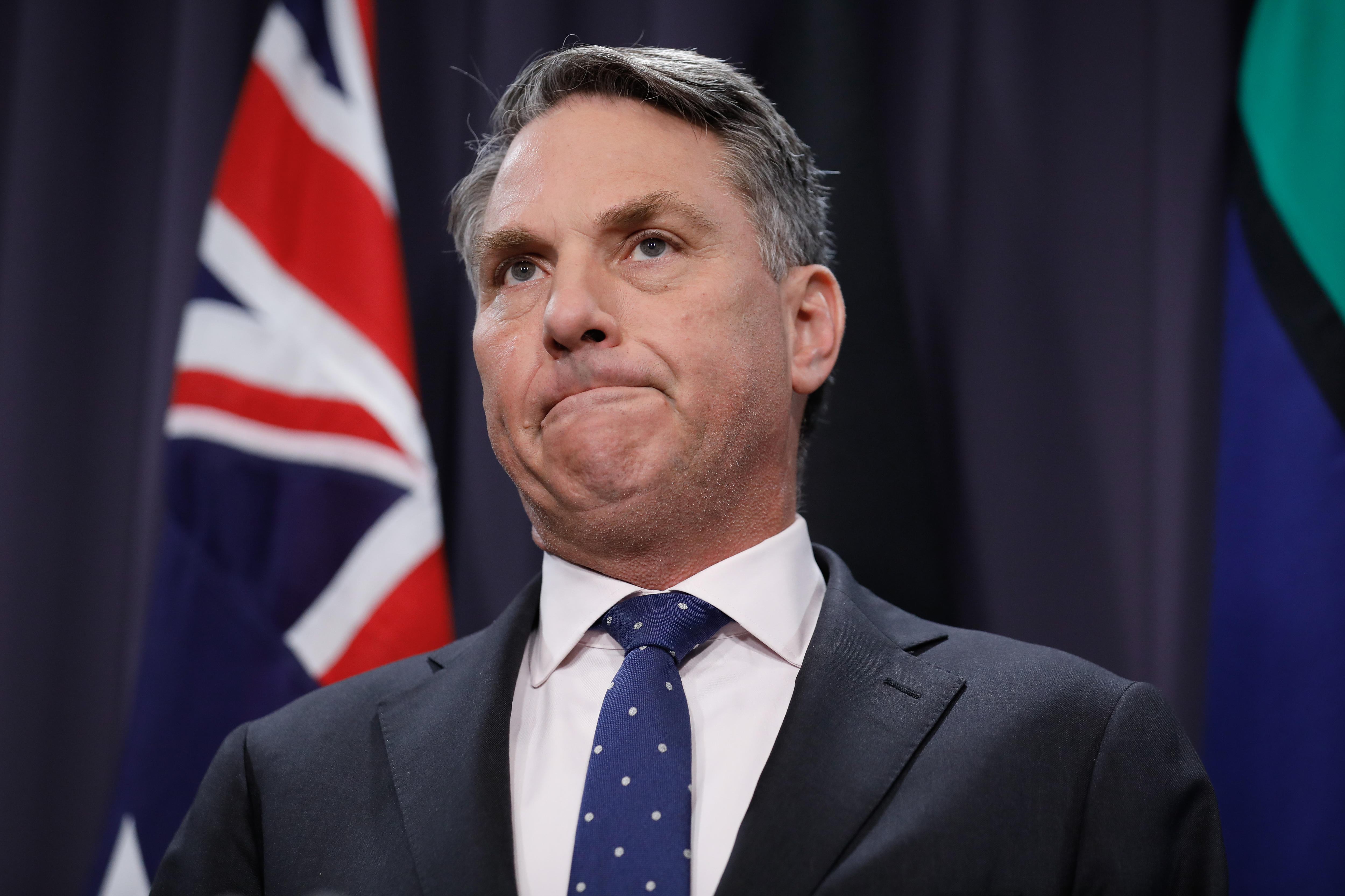 Richard Marles speaking in front of Australian flags in the Blue Room at Parliament House 