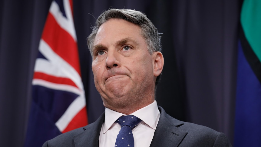 Richard Marles speaking in front of Australian flags in the Blue Room at Parliament House 