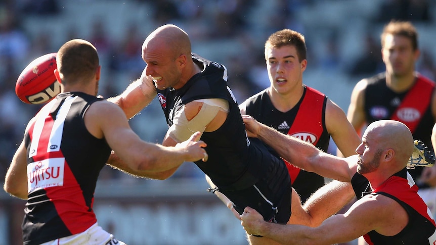 Chris Judd is hauled in by the Essendon defence
