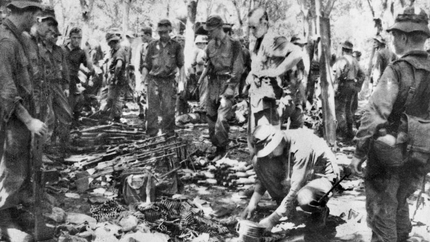 Peter Slack-Smith (kneeling) and members of D Company with enemy weapons found after the Battle of Long Tan.