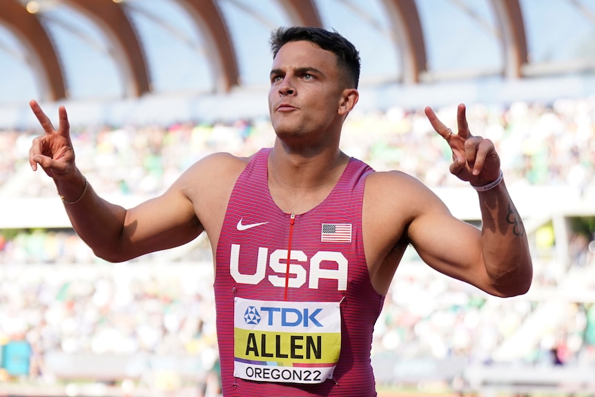 Sprinter Devon Allen gives peace signs with both hands after a 110m hurdles race at the world athletics championships.