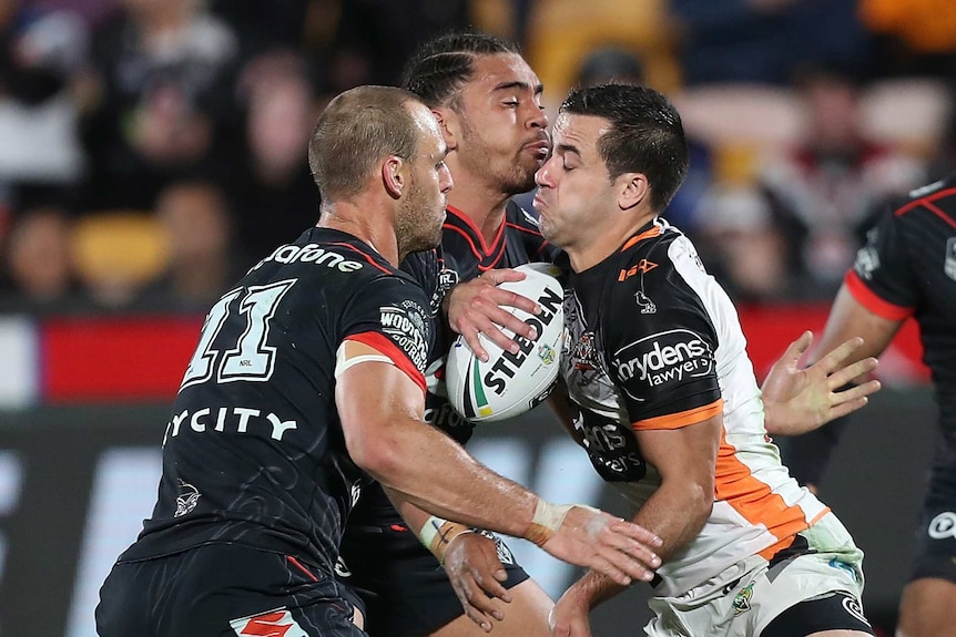 Corey Thompson about to be tackled by Simon Mannering and Isaiah Papali'i.