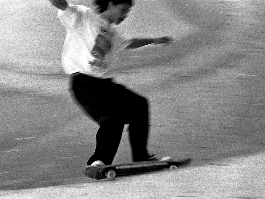 Ett grynigt svartvitt foto av en skateboardåkare