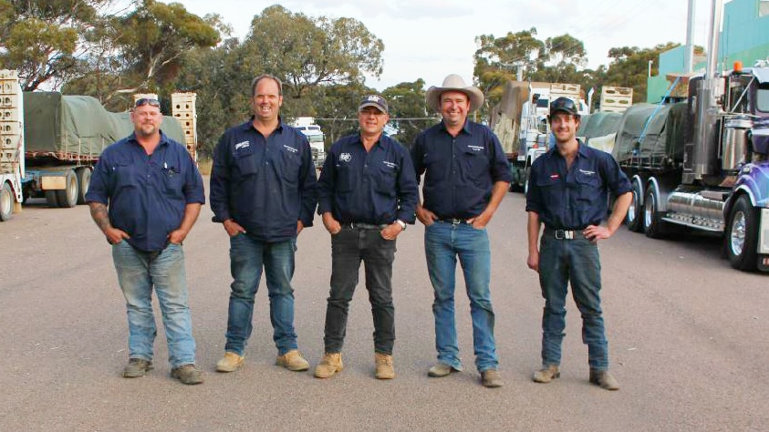 Truck drivers standing in front of trucks