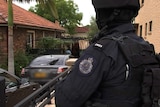 A police officer looking at a house.