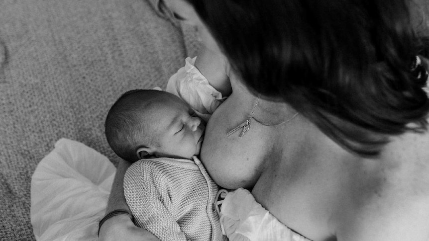 A woman breastfeeding her child in a photo