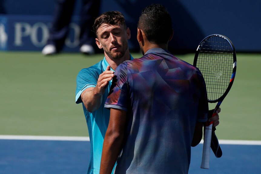 John Millman hugs Nick Kyrgios at the net following their US Open match.