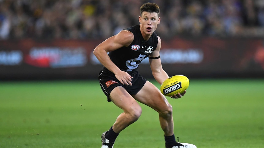 A Carlton AFL players holds the ball during a 2019 match against Richmond at the MCG.