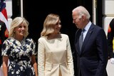 Ukraine's first lady Olena Zelenska stands with US first lady Jill Biden on her left while looking at US president Joe Biden.