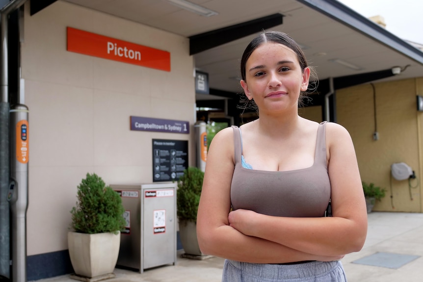 Teenage girl stand with arms folded at the Picton train station.