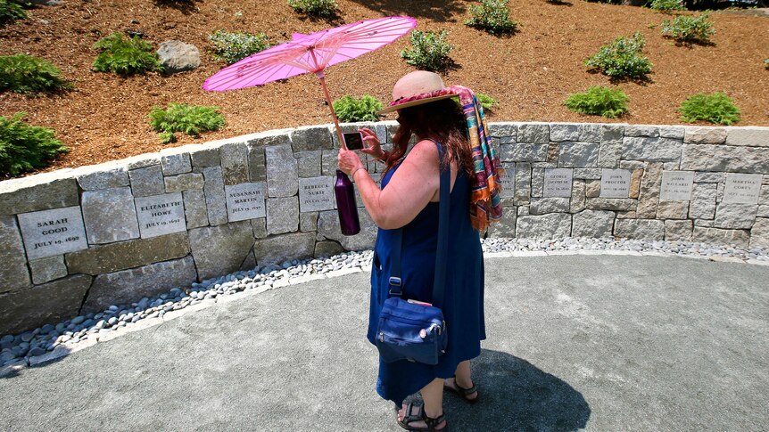 A teacher standing in front of a memorial site in Salem, Massachusetts 