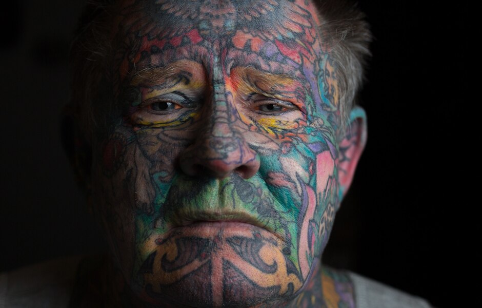 Close-up portrait of John Kenney's tattooed face