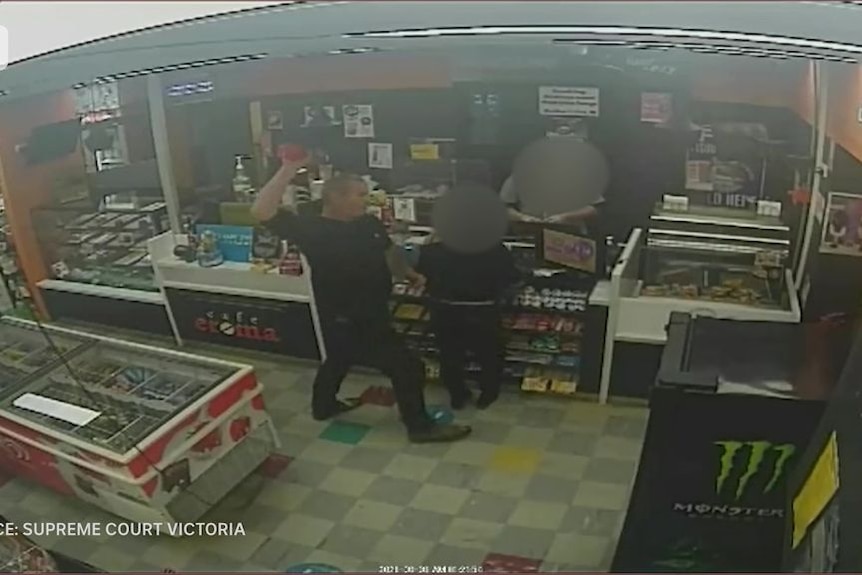 CCTV footage shows a man with his arm raised about to throw a sports drink inside a service station.