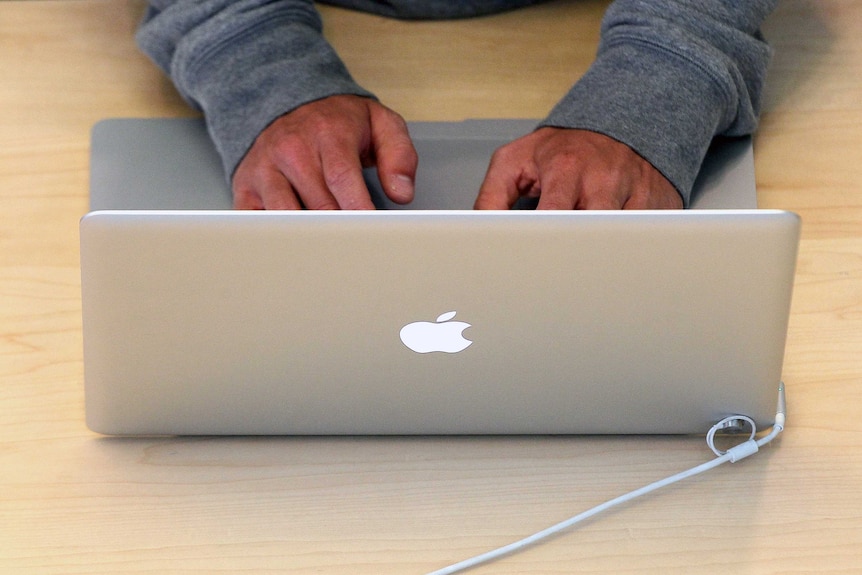 Man types on Apple MacBook