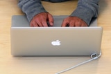 Man types on Apple MacBook