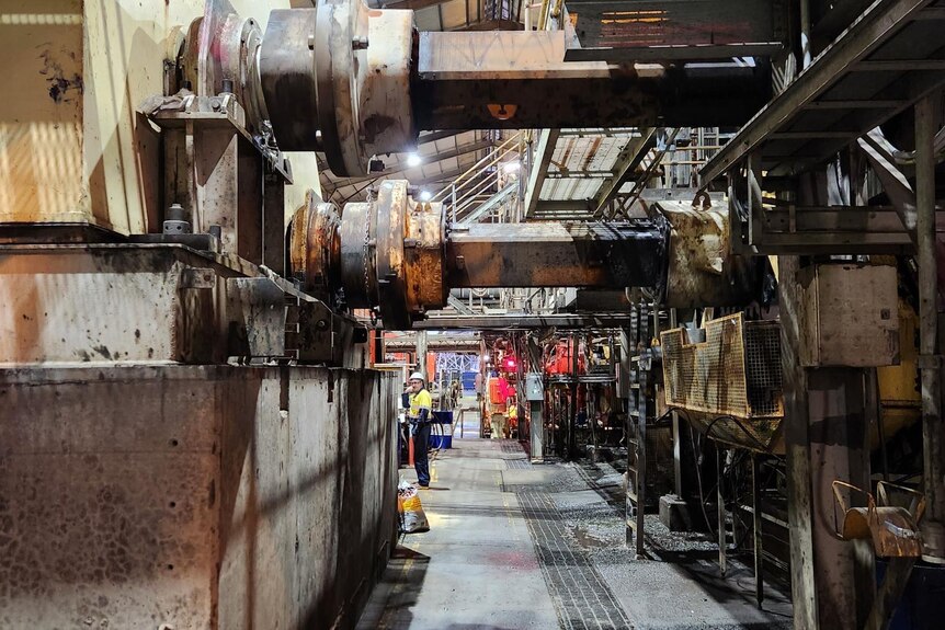 Workers wearing hi-vis in the distance inside the Broadwater Sugar Mill.