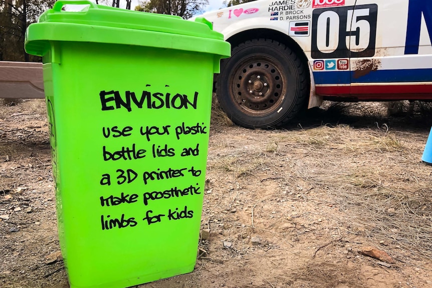 Bright green wheelie bin that is used to collect bottle lids to turn into prosthetic limbs