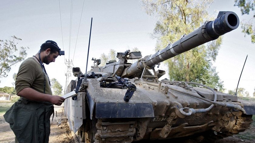 An Israeli soldier prays next to a tank near the northern Israeli-Gaza Strip border
