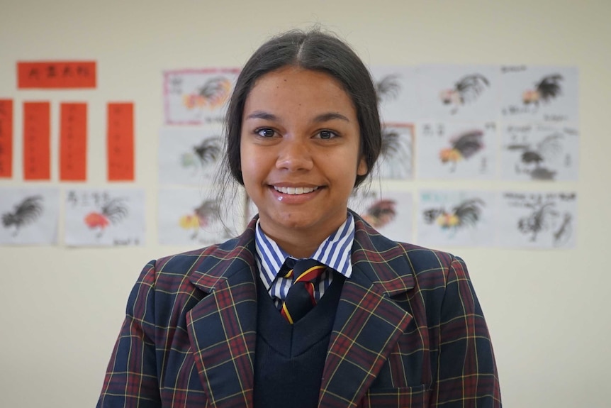 Tanaya Williams smiles in her private school uniform.