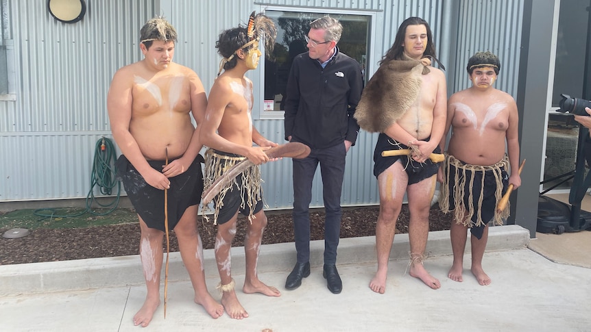 a man wearing glasses standing with young Indigenous men 