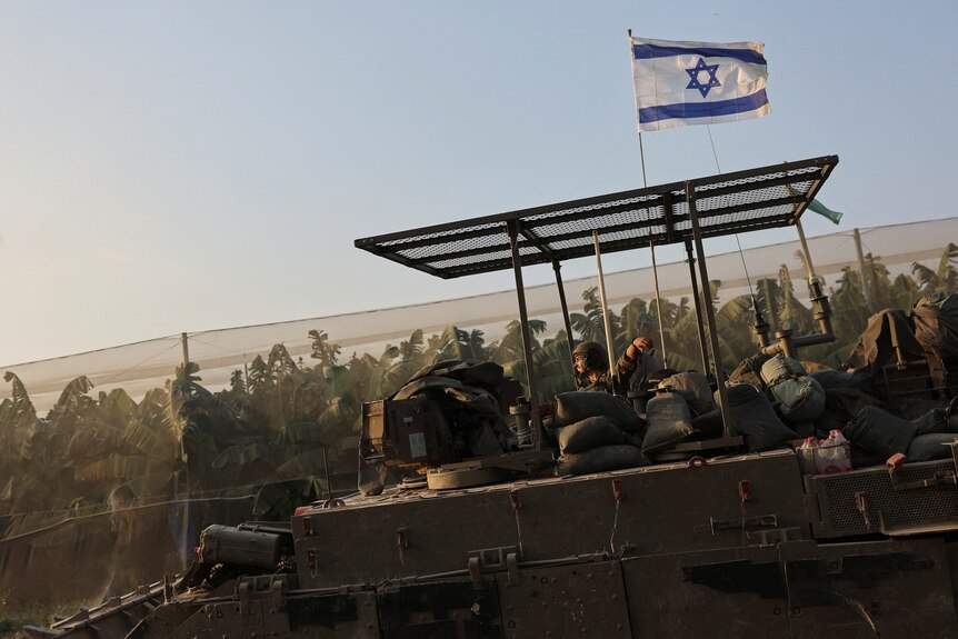 An israeli soldier rides in an armoured personnel carrier near the Israel-Gaza border