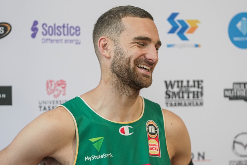A basketball player speaks to media off camera.