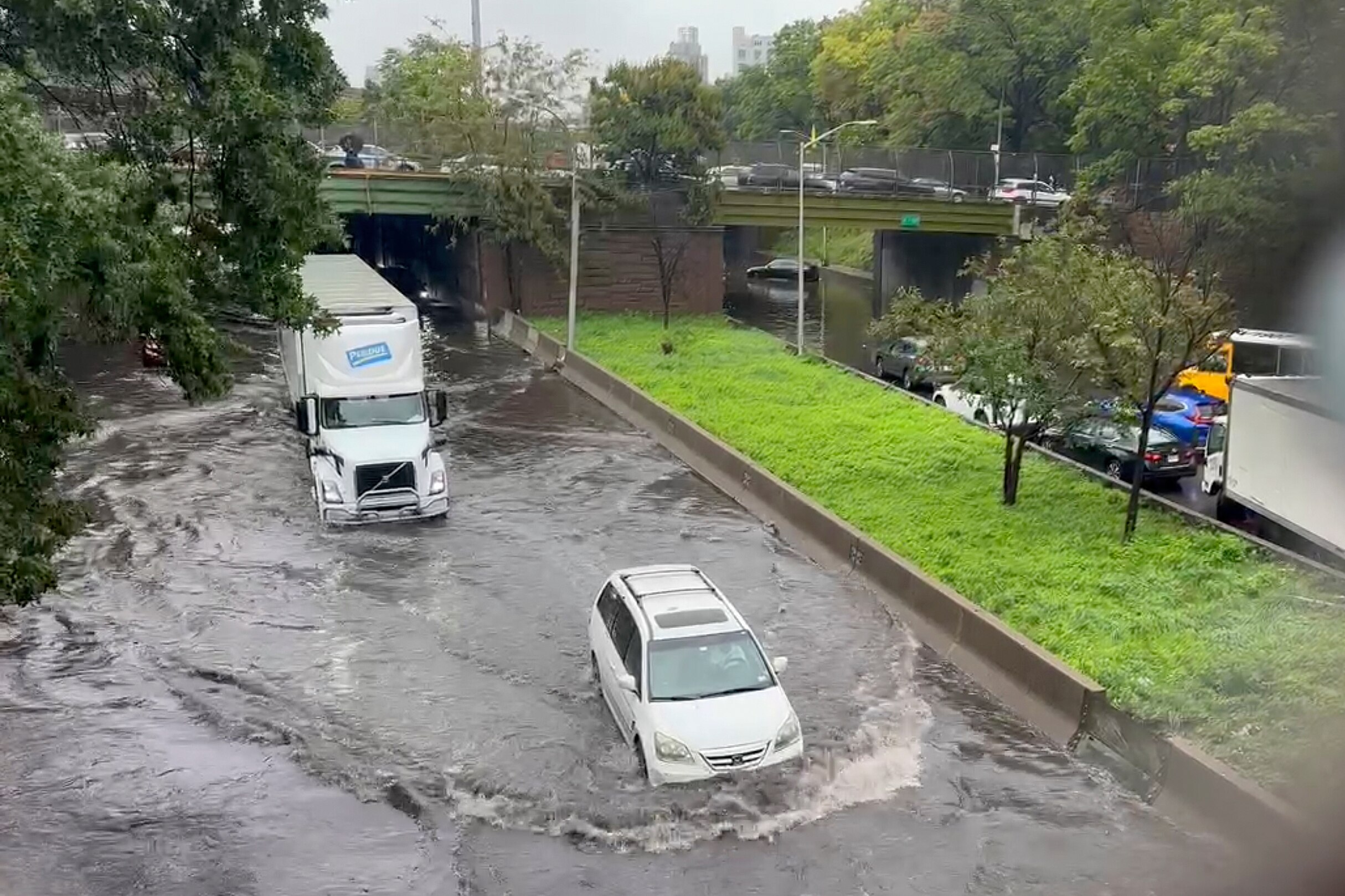 Two cars driving through floodwaters.