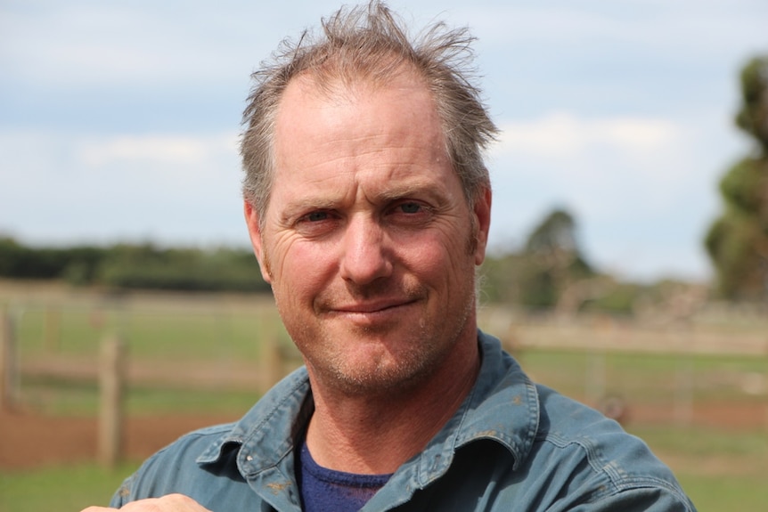 Dairy farmer Adam Jenkins leaning on a fence at his south west Victorian property