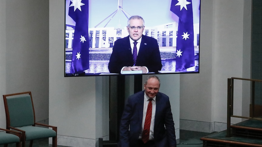 Barnaby Joyce ducks under Scott Morrison, who is on a screen appearing in Question Time virtually