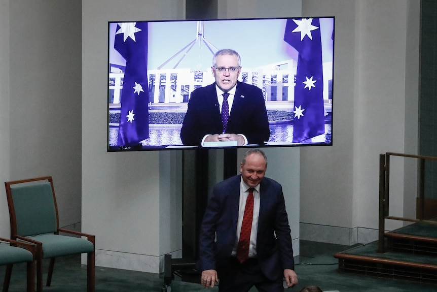 Barnaby Joyce ducks under Scott Morrison, who is on a screen appearing in Question Time virtually