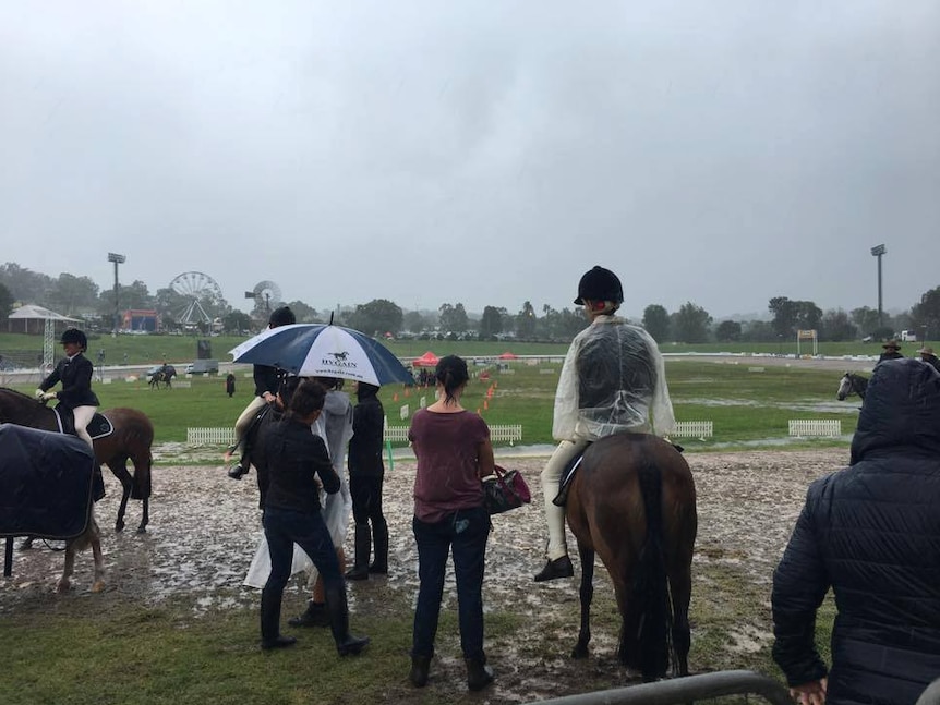 Equestrian competitors look over a water-logged Toowoomba Showgrounds