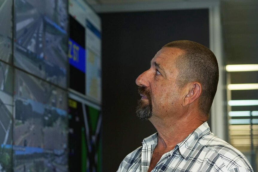 A photo of Ian Smith gazing up at a screen.