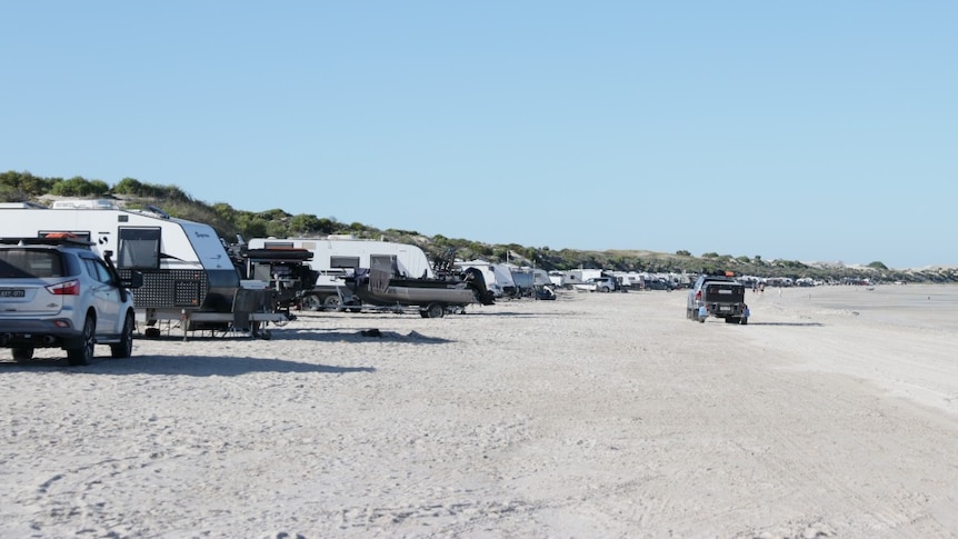 white sandy beach. sand dunes, cars, caravans, trailers, driving
