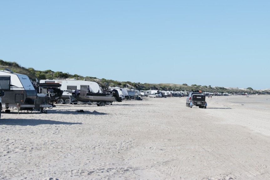 white sandy beach. sand dunes, cars, caravans, trailers, driving