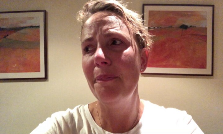 A crying woman looks off camera.