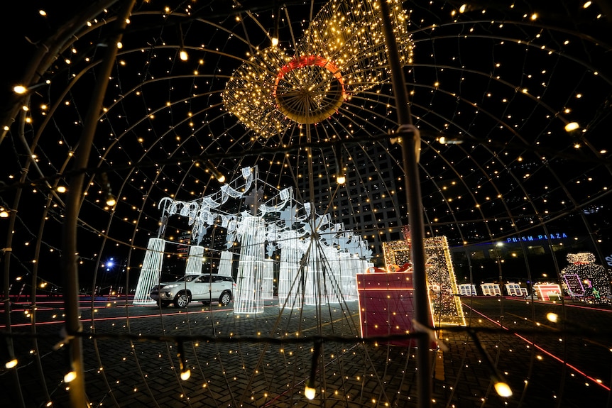 A car drives past Christmas exhibits at a Christmas drive-through installation outside a shopping mall in Pasay, Philippines 